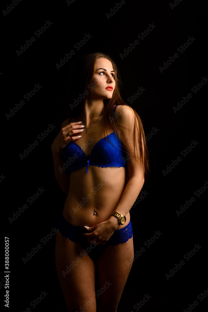 Beautiful sexy woman in blue underwear on dark background, perfect female body, studio shot