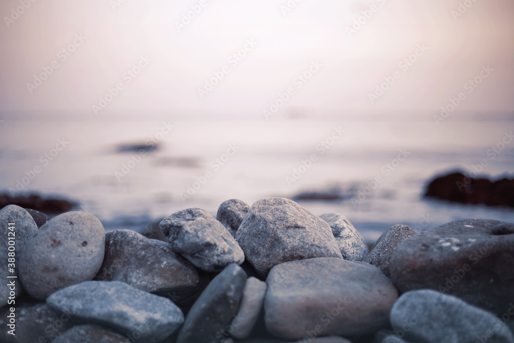 Pebble stones on the shore close up in the blurry sunset light Pebble stones on the shore close up in the blurry sunset light