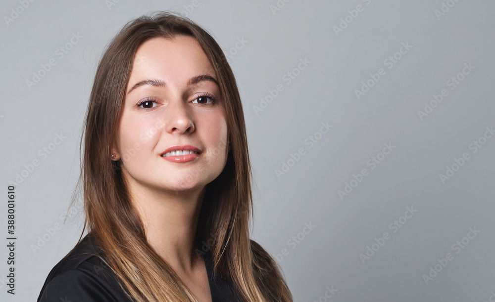 Portrait of young smiling woman on gray background Portrait of young smiling woman on gray background