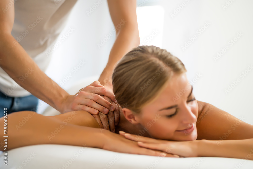 Professional masseur doing therapeutic massage. Woman enjoying massage in her home. Young woman getting relaxing body massage. Professional masseur doing therapeutic massage. Woman enjoying massage in her home. Young woman getting relaxing body massage.