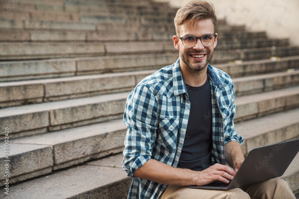 Young smiling man sitting on steps Young smiling man sitting on steps