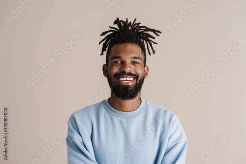 Joyful african american guy smiling and looking at camera photo