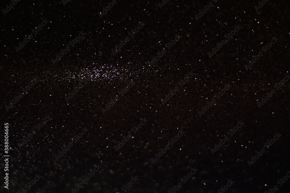 Fototapeta premium Black shiny glitter background, glowing blurred pattern for Christmas and New Year cards