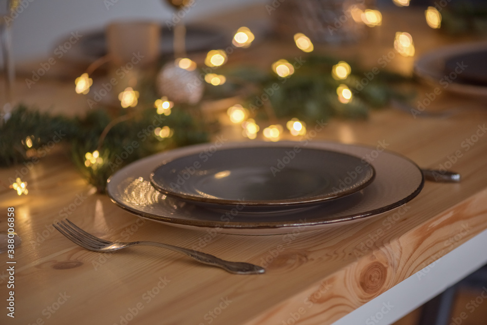 A glass of champagne in the background of the Christmas table and the lights of the Christmas tree