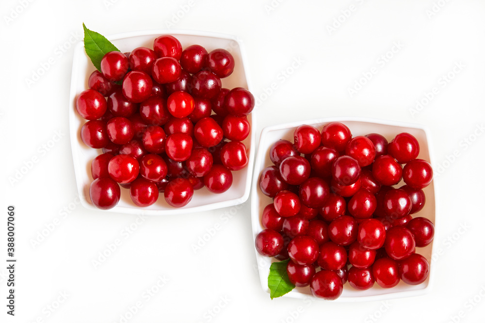 Fresh cherries on two plates on a white background. fresh ripe cherry. view from above Fresh cherries on two plates on a white background. fresh ripe cherry. view from above