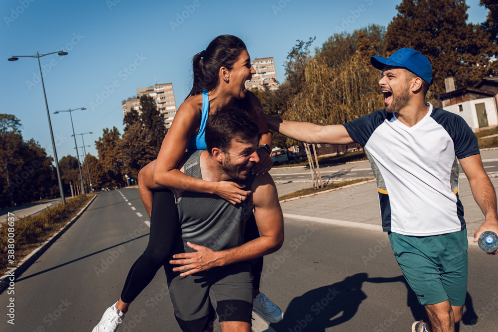 Group of young people in sports clothing having fun during morning workout in the city.