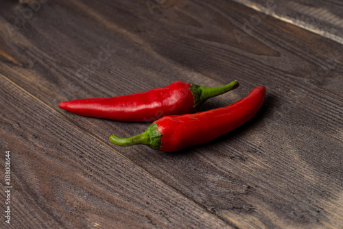 Two fresh chili peppers on a dark wood background, copyspace