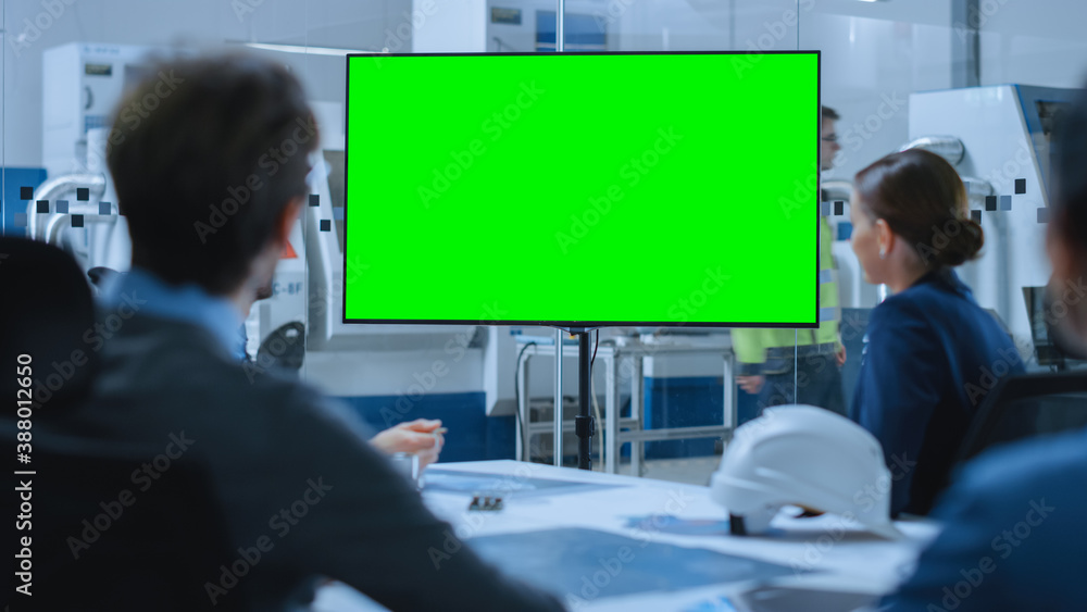 Modern Factory Office Meeting Room: Diverse Team of Engineers, Managers and Investors Talking at Conference Table, Watching Interactive TV that shows Green Screen Chroma Key Mock-up - obrazy, fototapety, plakaty 