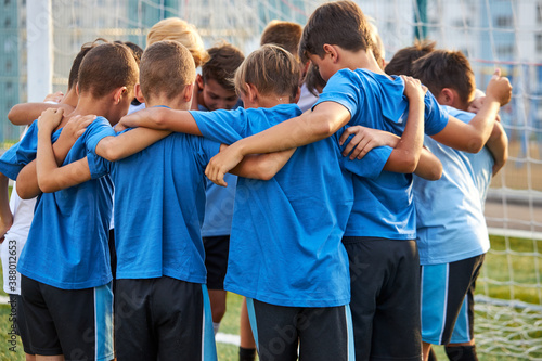 little kids of soccer team gathered before the tournament final match, young football players huddling