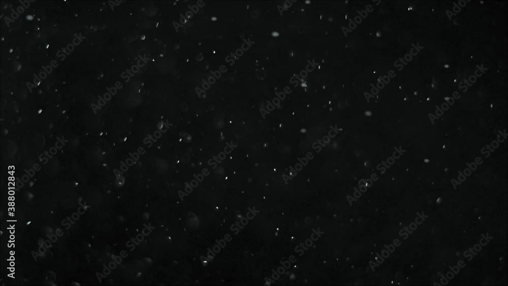 Christmas snowflakes swirl and fall slowly against a black background. Christmas and New Year decoration Christmas snowflakes swirl and fall slowly against a black background. Christmas and New Year decoration