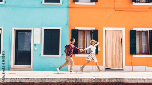 Couple of happy tourists visiting Burano, Italy - Boyfriend and girlfriend in love spending a romantic weekend in Venice, Italy. © Davide Angelini