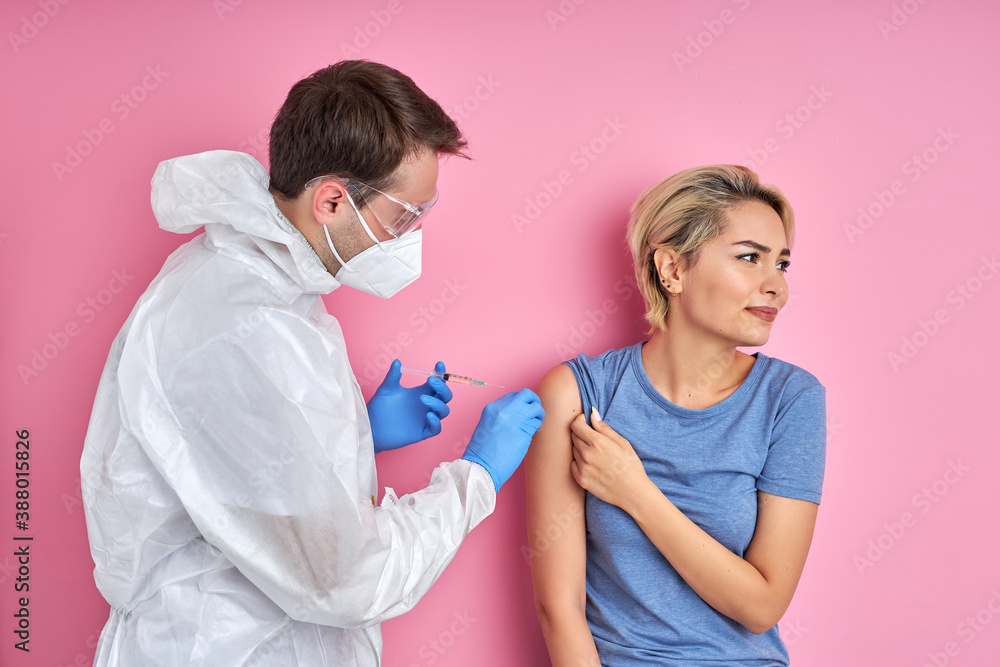 confident doctor with syringe doing injection vaccine,flu,influenza in the shoulder of young caucasian woman, healthcare concept confident doctor with syringe doing injection vaccine,flu,influenza in the shoulder of young caucasian woman, healthcare concept