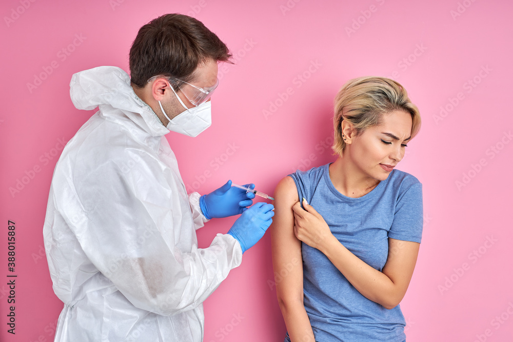confident doctor with syringe doing injection vaccine,flu,influenza in the shoulder of young caucasian woman, healthcare concept - obrazy, fototapety, plakaty 