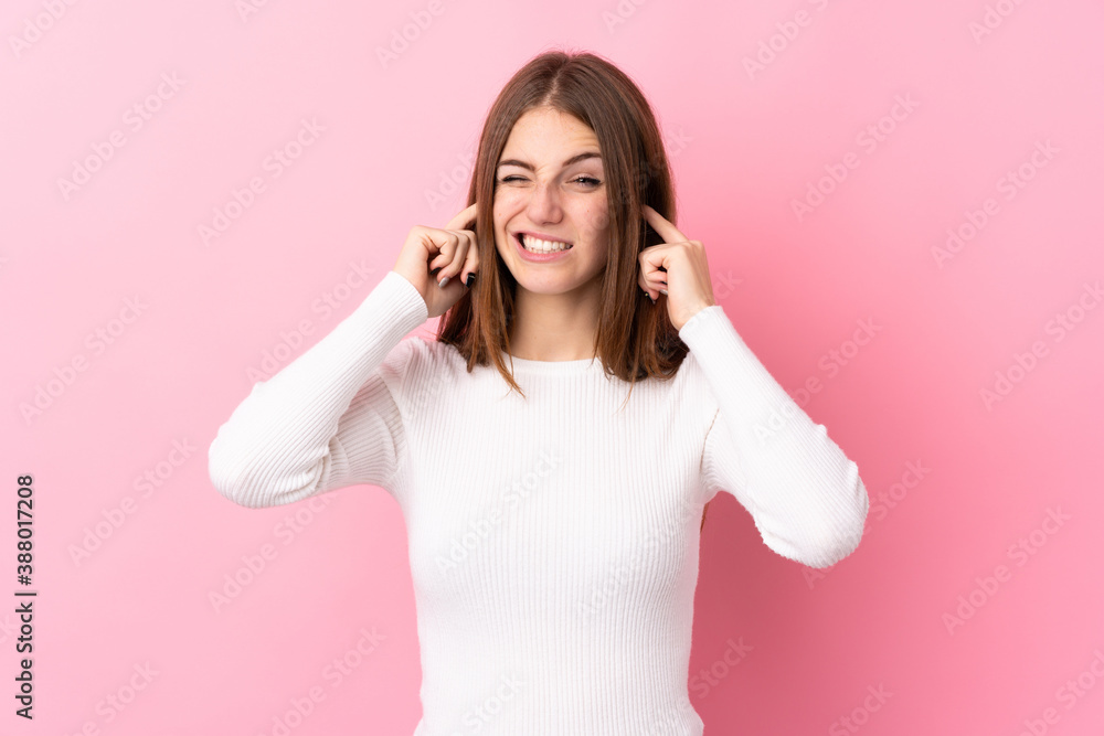 Young woman over isolated pink background frustrated and covering ears Young woman over isolated pink background frustrated and covering ears