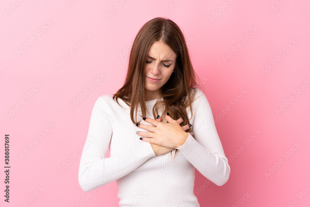 Young woman over isolated pink background having a pain in the heart Young woman over isolated pink background having a pain in the heart