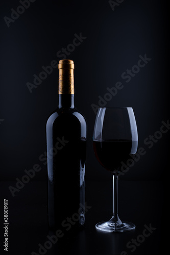 closeup wine bottle and glass with black background