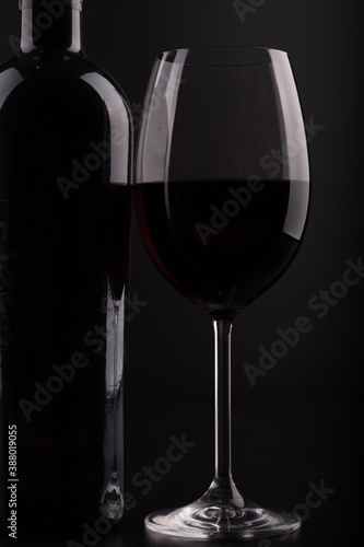 closeup wine bottle and glass with black background