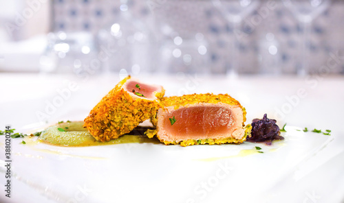 Tuna dish with pistachios crust on the plate in the restaurant