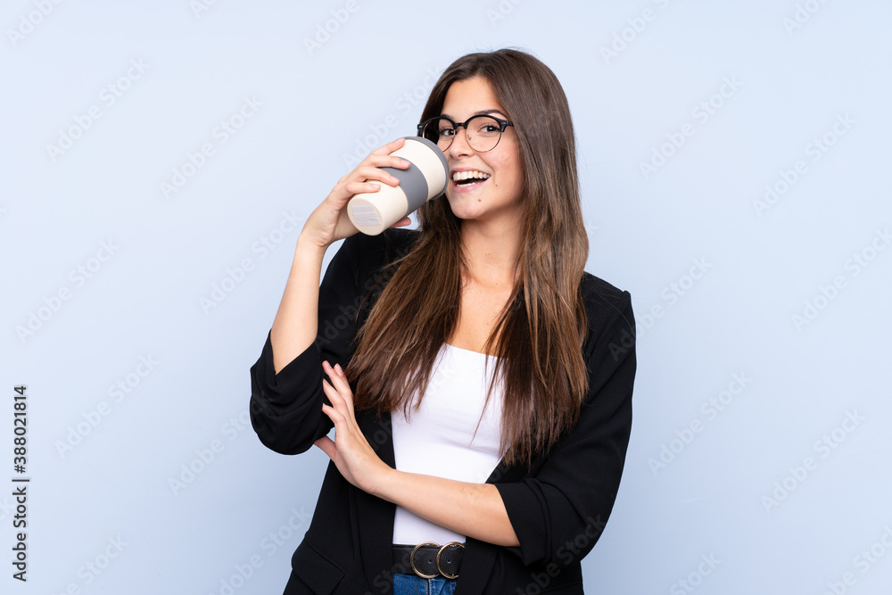 Young Brazilian business woman holding coffee to take away over isolated blue background Young Brazilian business woman holding coffee to take away over isolated blue background