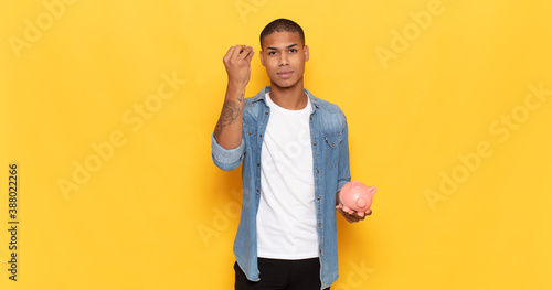 young black man making capice or money gesture, telling you to pay your debts! photo