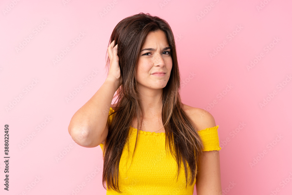 Teenager Brazilian girl over isolated pink background having doubts Teenager Brazilian girl over isolated pink background having doubts
