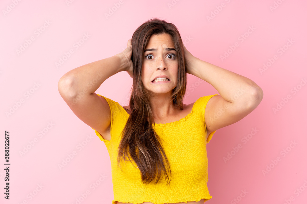Fototapeta premium Teenager Brazilian girl over isolated pink background frustrated and takes hands on head