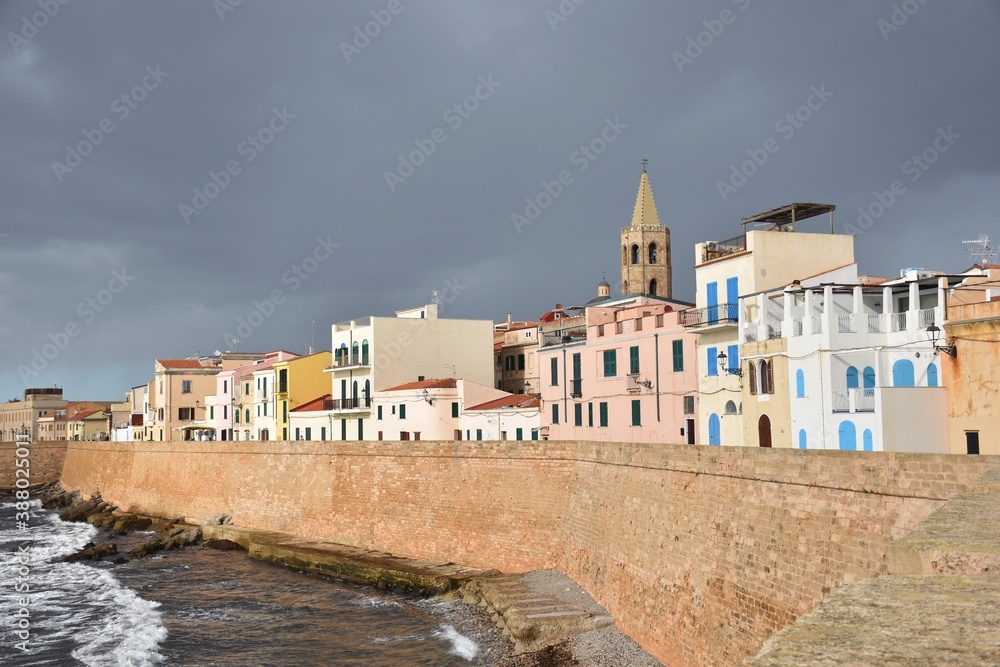 Skyline of the historic town of Alghero lighted by the sun on a stormy day, Sardinia/Italy