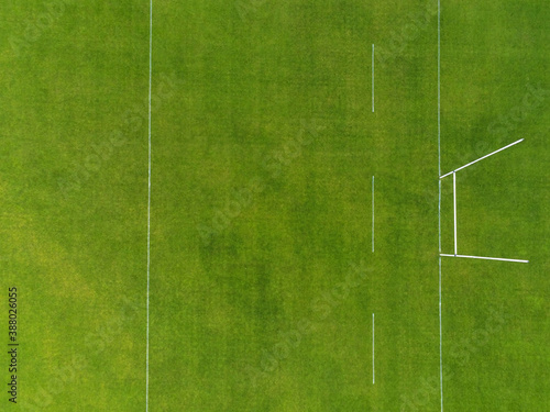 Aerial view on a green grass training pitch with tall goal posts for popular Irish National sports: hurling, camogie,gaelic football, rugby. Nobody on the pitch. Outdoors activity concept