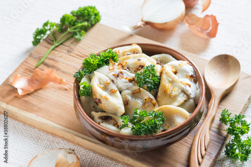 A bowl of russian varenyky, vareniki, Dumplings served with fried onion. Pyrohy - dumplings with filling. Selective focus, close-up photo