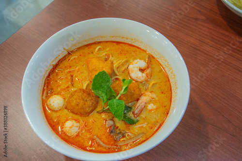 Penang's 'Curry mee' dish made with noodles in a coconut based gravy, combined with fragrant chilli paste and garnished with cuttlefish, prawns, fish ball and cockles in Kuala Lumpur, Malaysia