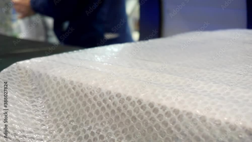 packing machine packs the finished product in a plastic film. close-up. packing machine packs the finished product in a plastic film. close-up.