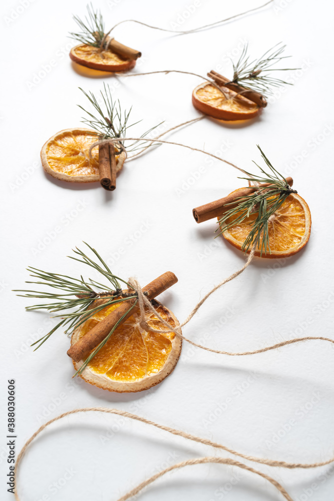 Φωτογραφία Christmas garland of dried oranges, pine twigs and cinnamon sticks strung on a string