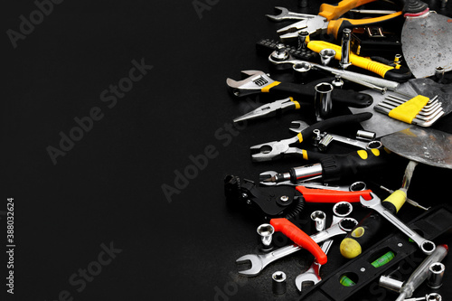 Many different tools for repair work on a black background with copy space for text.