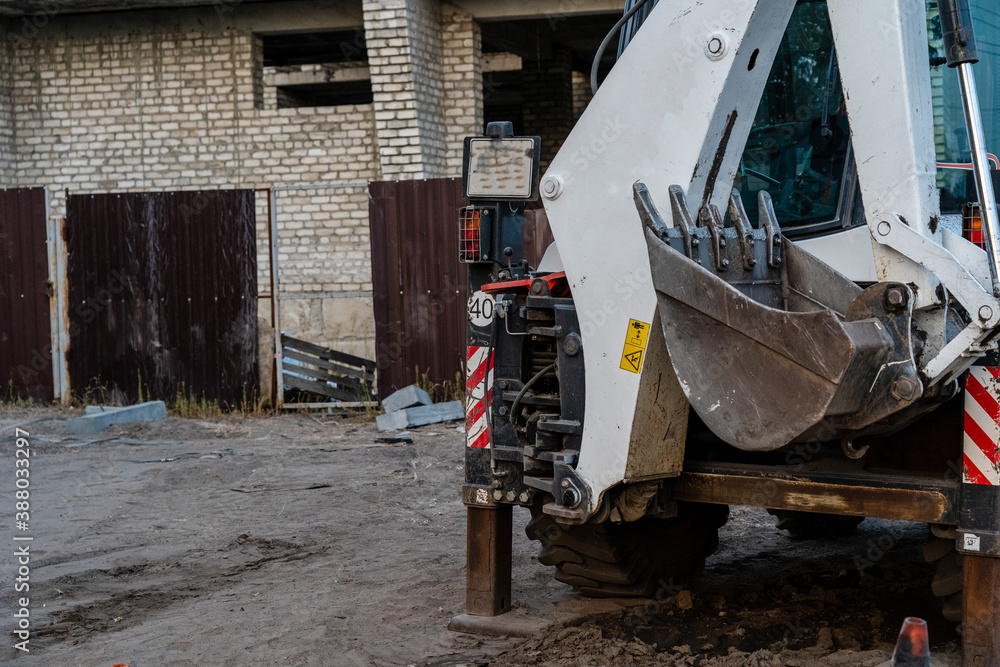 Old tractor standing near building construction Old tractor standing near building construction