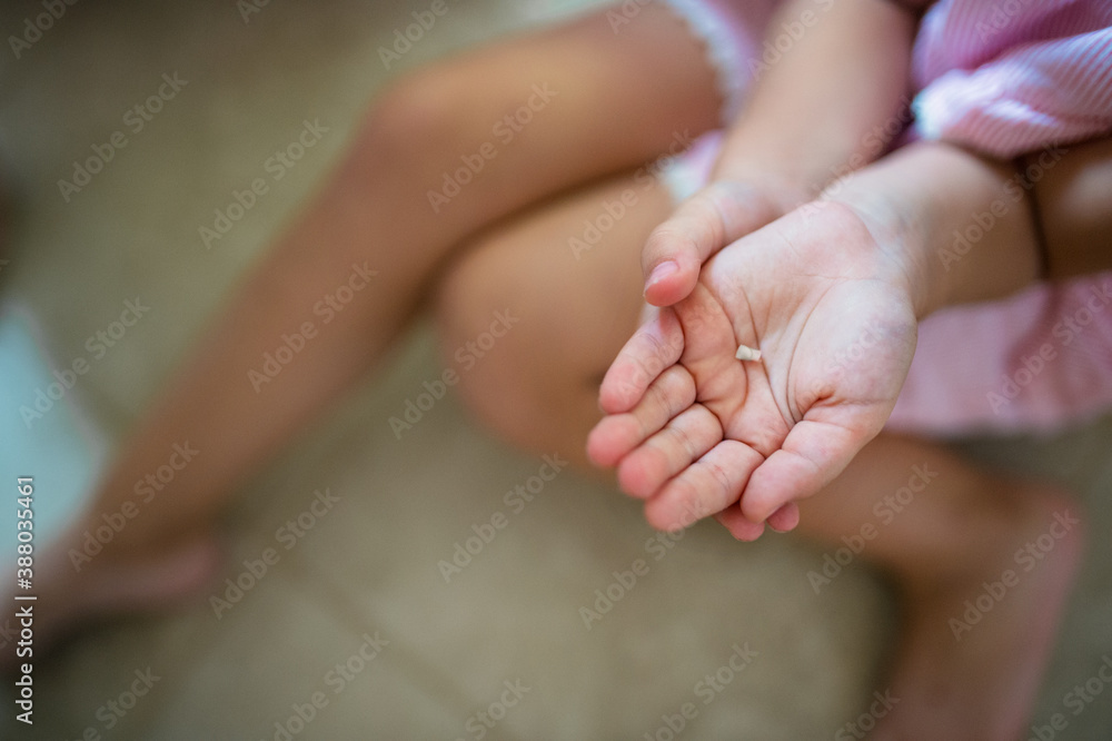 Unrecognizable small girl indoors, loosing baby tooth. Unrecognizable small girl indoors, loosing baby tooth.