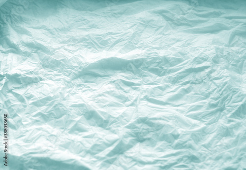 Crumpled paper background in cyan tone.