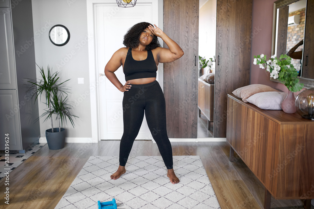 sweaty chubby woman after sport exercises at home , tired woman in black  top and leggins want to loss weight Photos | Adobe Stock