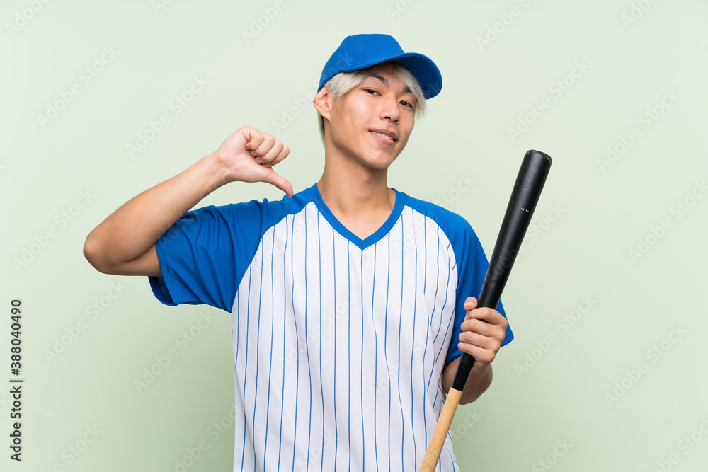 Young asian man playing baseball over isolated green background proud and self-satisfied Young asian man playing baseball over isolated green background proud and self-satisfied