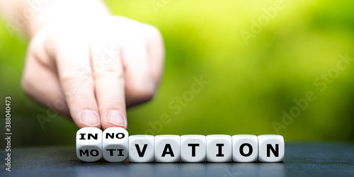 From a motivation to a innovation. Hand turns dice and changes the word motivation to innovation.