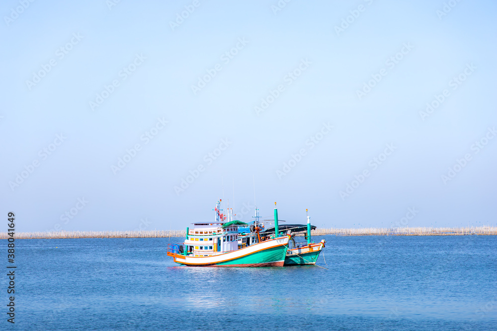 Fishing boats in the sea on a clear blue sky.