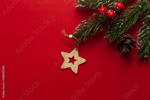 Wooden Christmas tree toy in the form of a star on a red background.