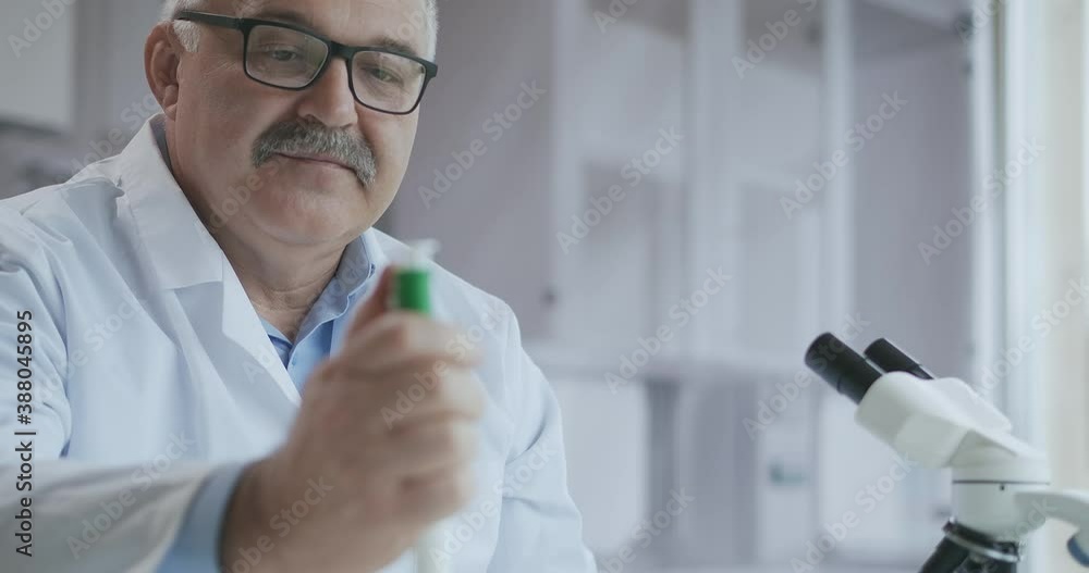 Microbiology Laboratory: Scientist Works with Various Bacteria. Concept of Pharmaceutical Research for Antibiotics, Curing Disease with DNA Enhancing Drugs. A man doctor with a microscope Microbiology Laboratory: Scientist Works with Various Bacteria. Concept of Pharmaceutical Research for Antibiotics, Curing Disease with DNA Enhancing Drugs. A man doctor with a microscope