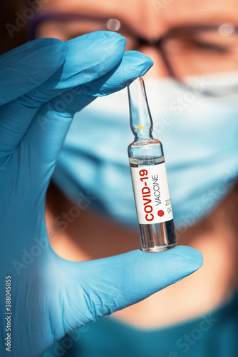 Coronavirus Japan-developed vaccine concept: vaccine with Japanflag in doctor hand with blue protective gloves. photo