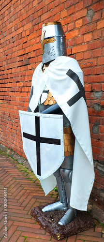 knight of the Teutonic order against a red brick wall