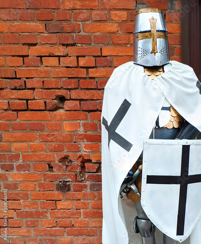 knight of the Teutonic order against a red brick wall