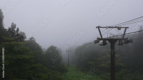 Flying away from misty ski lifts on a Japanese mountain top in summer. photo