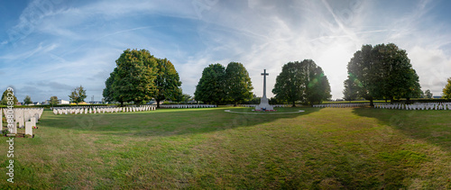 A panoramic view of the Bayeux War Cemetery in Normandy, France, where many British casualties of WW2 are laid to rest, in the late afternoon sun.