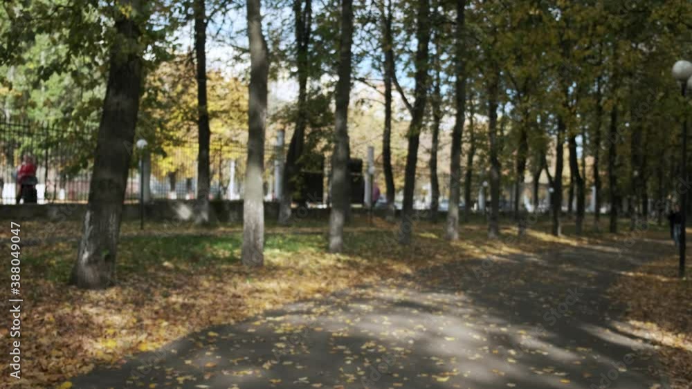 young caucasian busty woman stretching shoulders, arms outdoors, running away. pretty female in sportswear working out at autumn park. transport and unrecognisable people out of focus in background young caucasian busty woman stretching shoulders, arms outdoors, running away. pretty female in sportswear working out at autumn park. transport and unrecognisable people out of focus in background