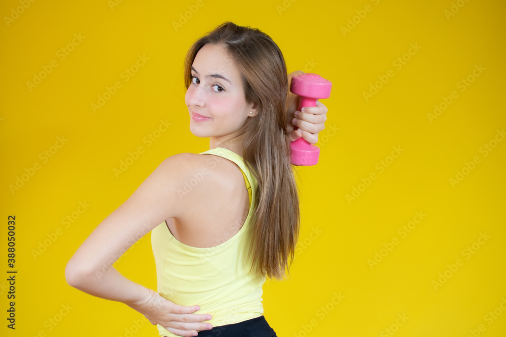 Attractive young fitness woman holding dumbbell. Studio shot. Attractive young fitness woman holding dumbbell. Studio shot.