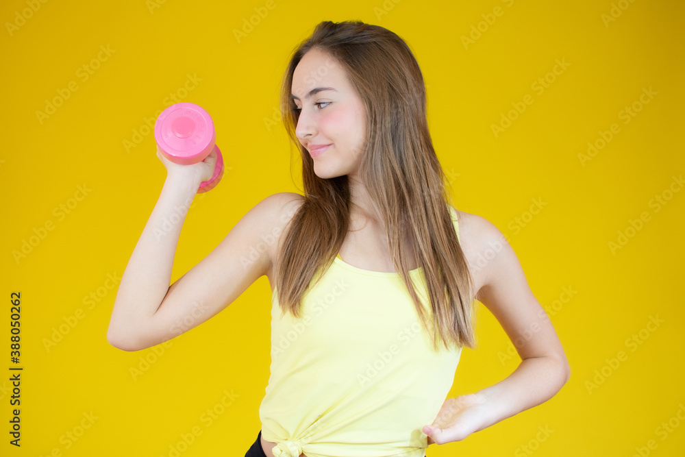 Attractive young fitness woman holding dumbbell. Studio shot. Attractive young fitness woman holding dumbbell. Studio shot.